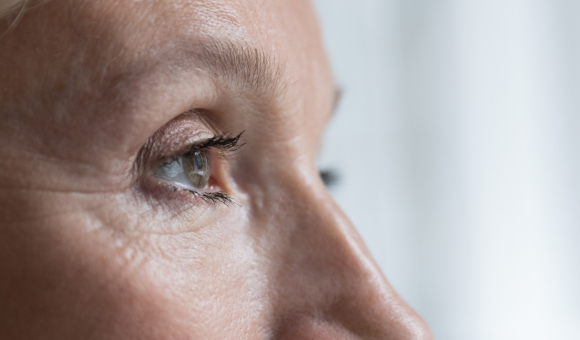 Close-up of a woman's eye from a side profile, showcasing her lashes, eyelid, and the shape of her eye