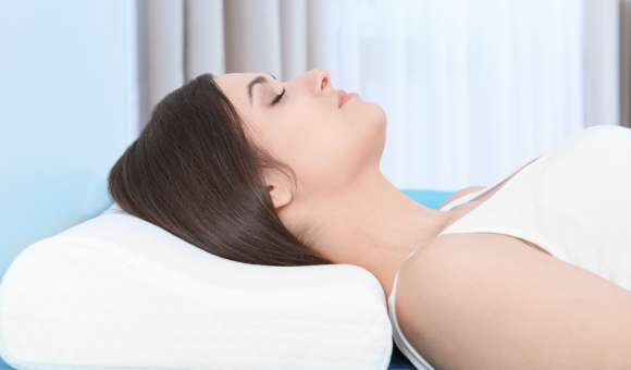 A woman lying on her back with her head elevated on a pillow