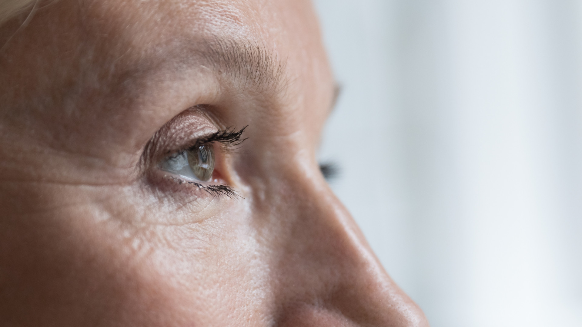 Close-up of a woman's eye from a side profile, showcasing her lashes, eyelid, and the shape of her eye